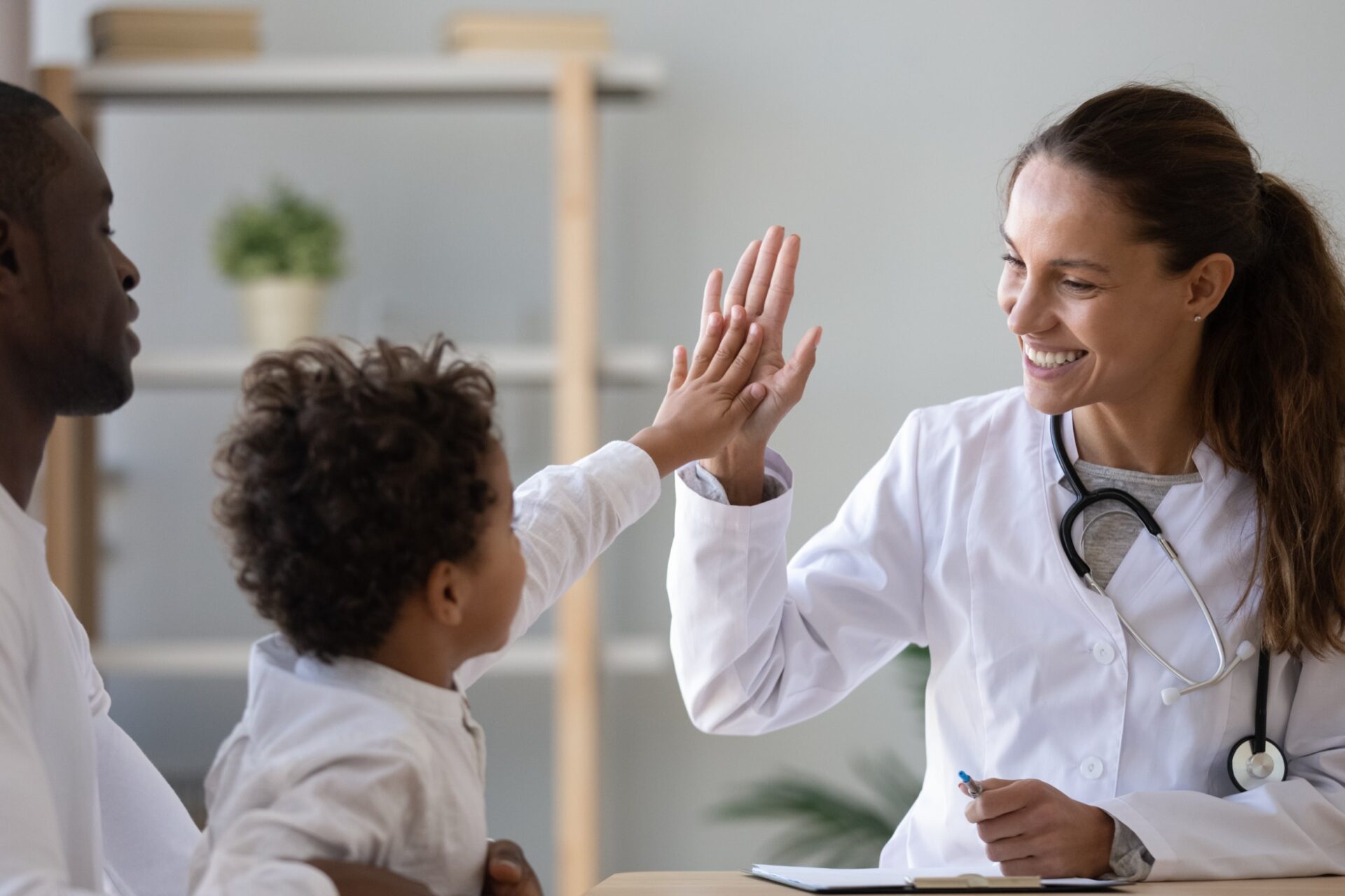 132462655_m_normal_none happy female doctor giving high fie to a little boy who came with father at hospital